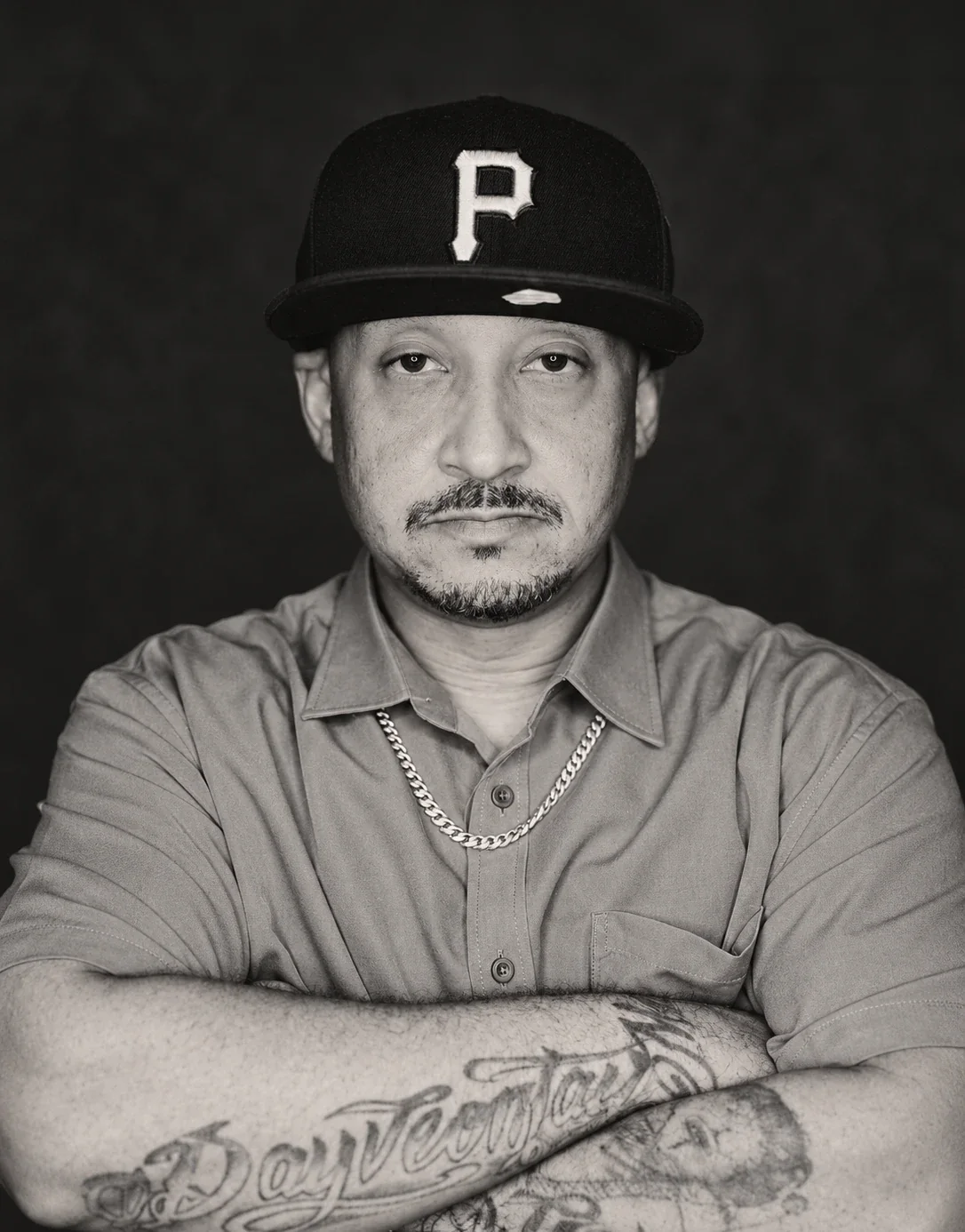 Paul in a baseball cap with arms crossed, in a black-and-white portrait